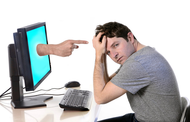 The guy at his computer which is pointing at him