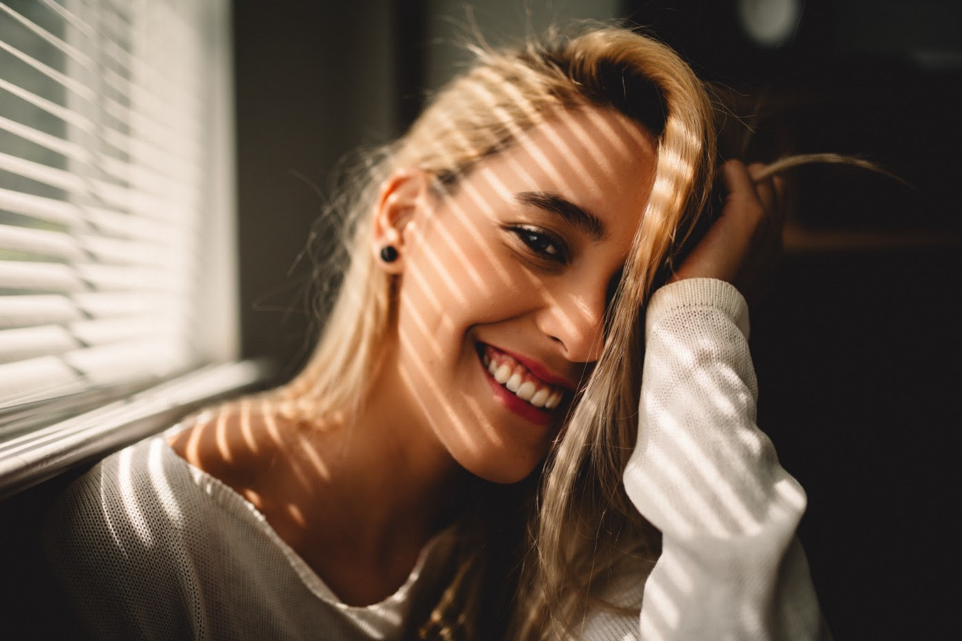 a smiling while woman with long hair looking at us