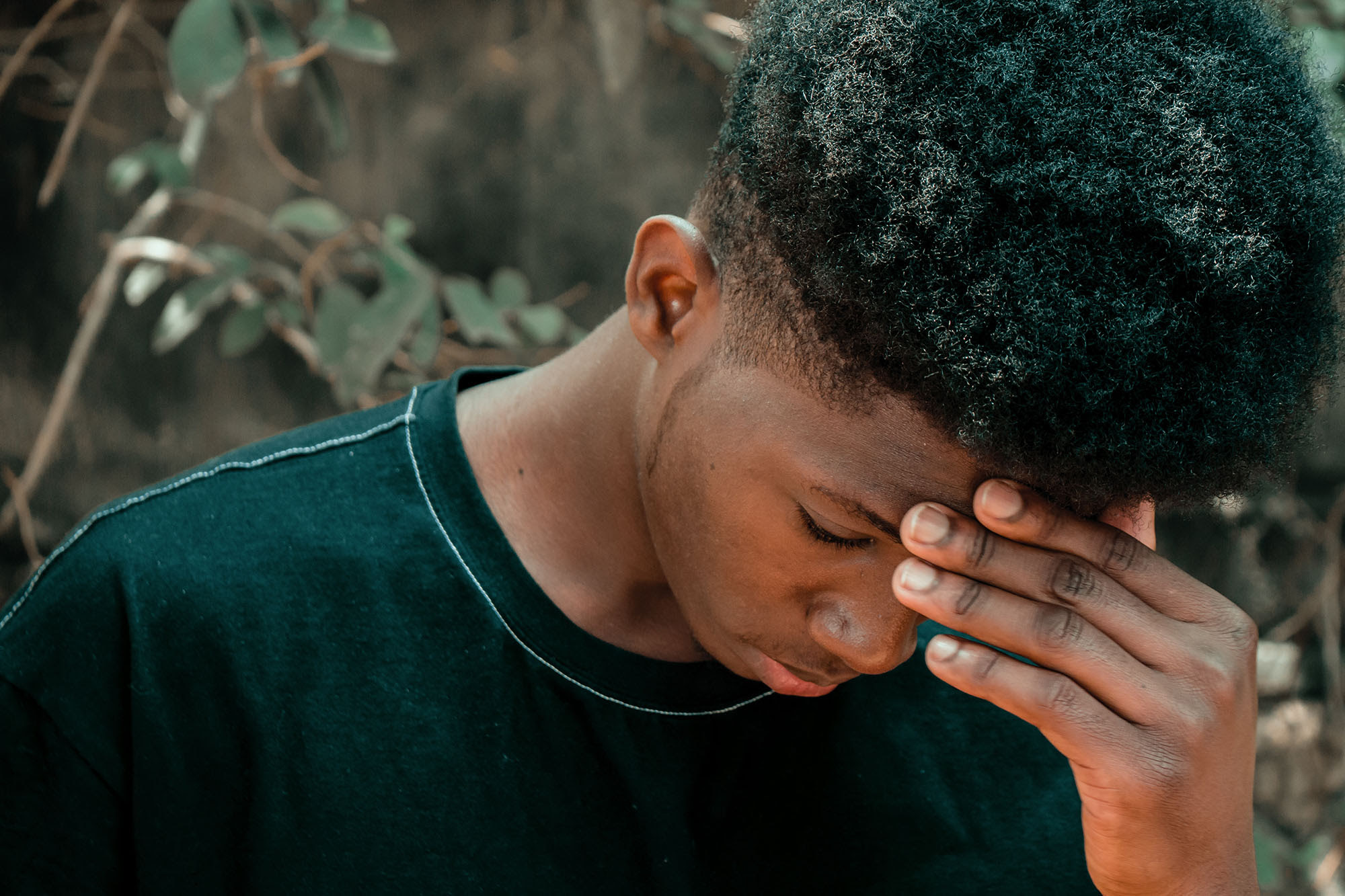 a color photo of a black man looking down