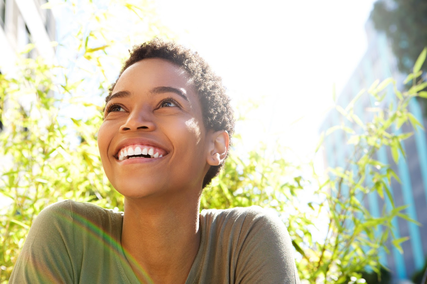 a smiling black woman with short hair, looking upward to our left