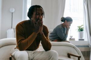  black couple sitting separately looking upset