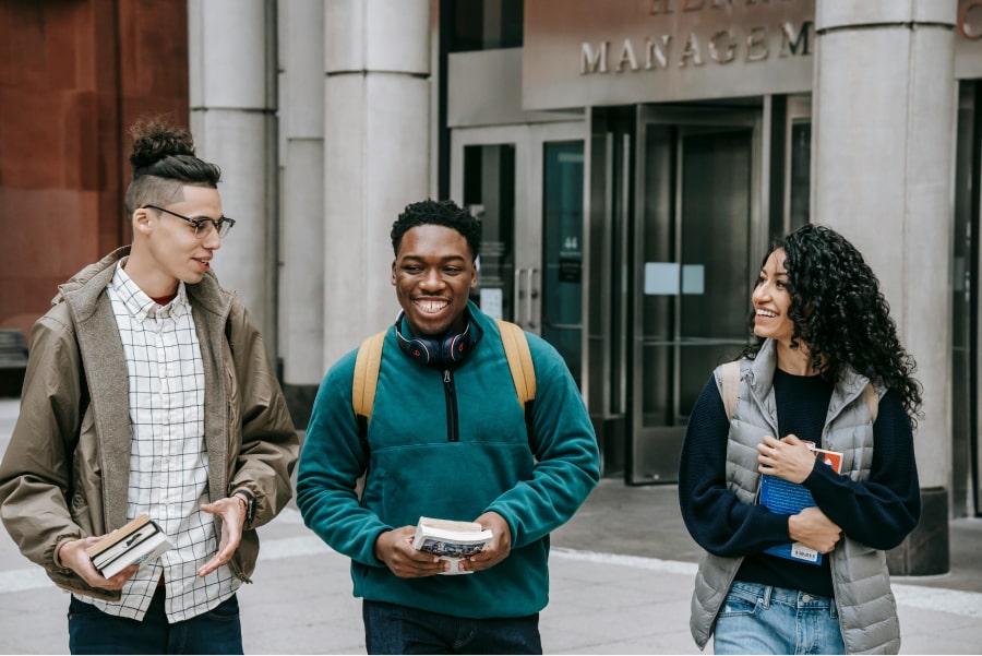 3 students holding books right