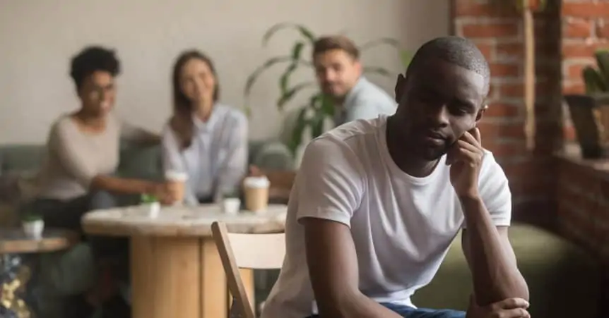 the young black man sitting apart from 3 others